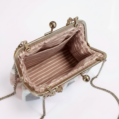 Bügeltasche „Facette“ geöffnet mit rosafarbenem Baumwollfutter, Innentasche und silbernem Bügel
